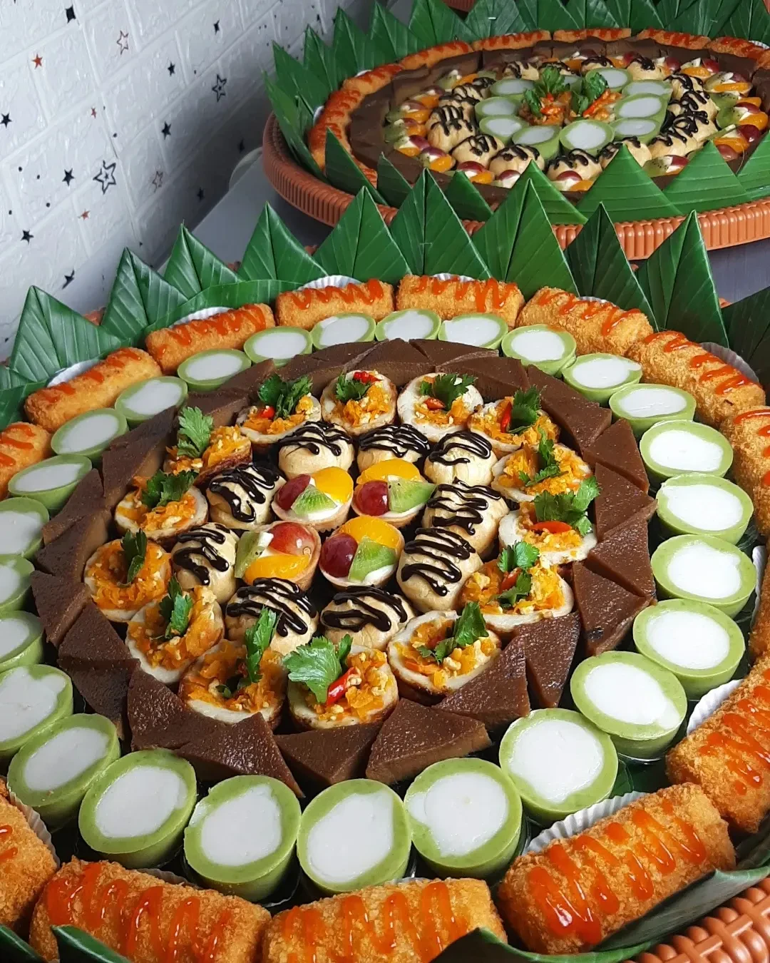 Nampan besar bertingkat berisi aneka kue tradisional